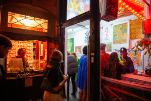 A lit DJ booth and a colourful shop with a group of people inside